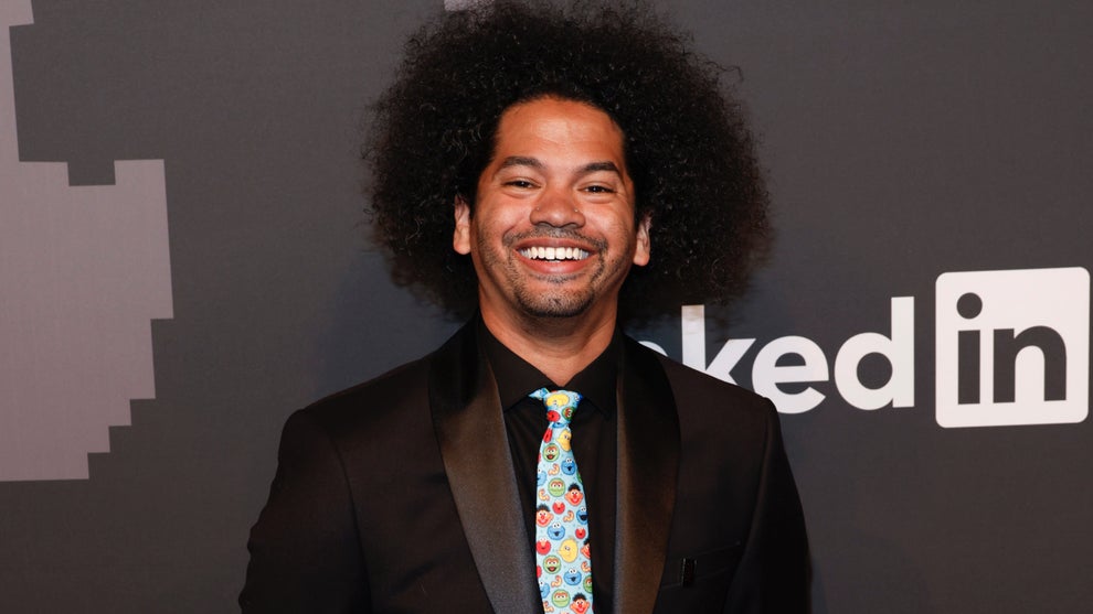 Mychal Threets poses behind a LinkedIn backdrop