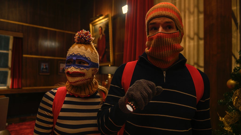 Olivia Holt and Connor Swindells wear holiday ski masks in "Jingle Bell Heist"