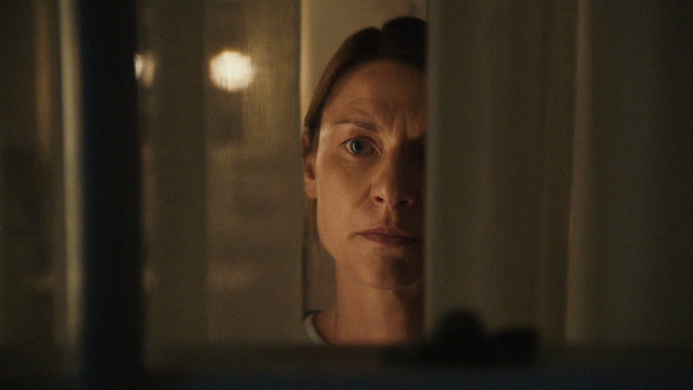 Claire Danes peers through a window in the trailer for "The Beast in Me" (Credit: Netflix)