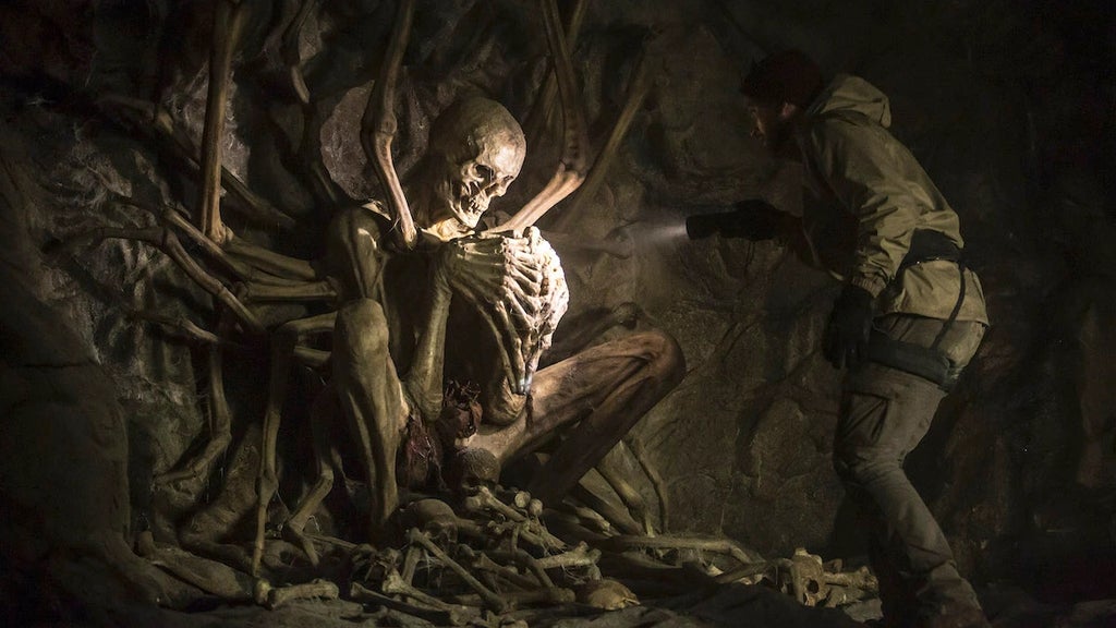 A man stumbles upon a large skeleton in a cave in "The Empty Man" (20th Century Studios) 