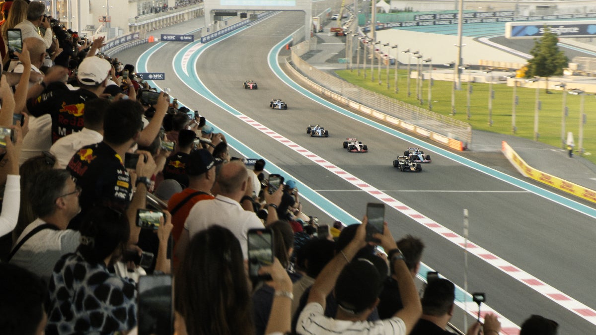 A crowd watches racing cars in "F1: The Movie"