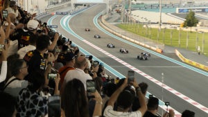 A crowd watches racing cars in "F1: The Movie"