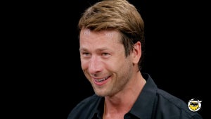 Glen Powell smiles on "Hot Ones"