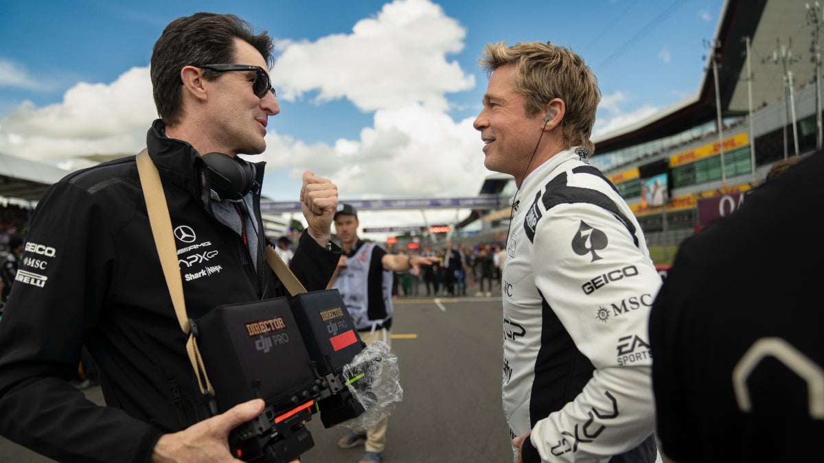 Joseph Kosinski talks to Brad Pitt on the racetrack while filming "F1"