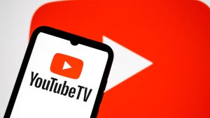 The YouTube TV logo appears on a smartphone screen, and the YouTube logo displays as the background on a laptop screen in this photo illustration in Athens, Greece, on November 2, 2025. (Credit: Photo Illustration by Nikolas Kokovlis/NurPhoto via Getty Images)