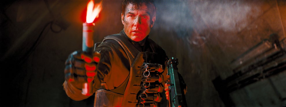 Tom Cruise wears tactical gear and holds a flare toward the camera in "Edge of Tomorrow"