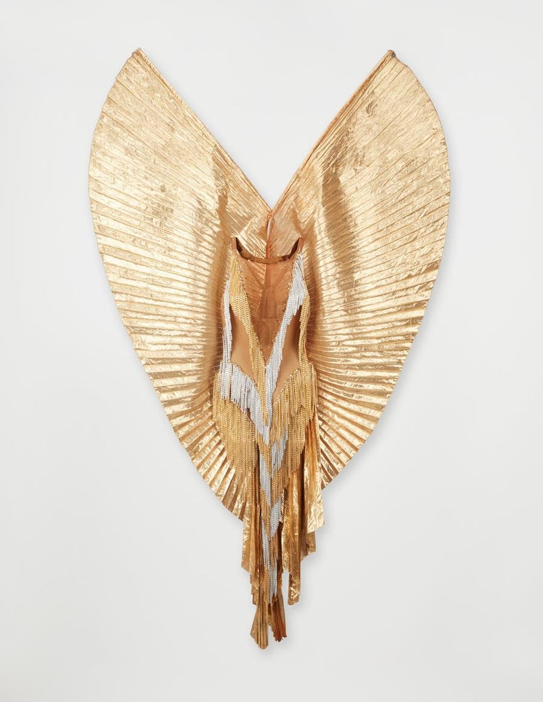 Part of the Julien's auction, a custom Bob Mackie gold and silver chain fringe bodysuit with pleated gold lamé wings sewn at the back, worn by Tina Turner for a 1977 Harry Langdon photo shoot. Source: Julien's Auctions