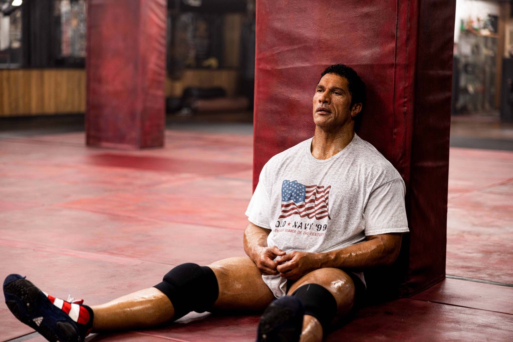 Dwayne Johnson rests against a mat in a gym in "The Smashing Machine"