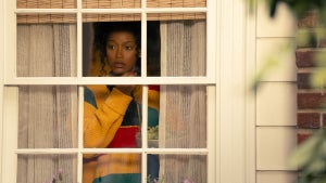 Keke Palmers looks concerned through a window