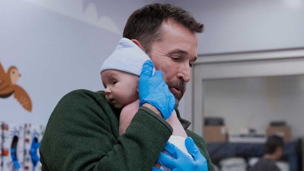 Noah Wiley holds a baby up to his shoulder in "The Pitt" Season 2