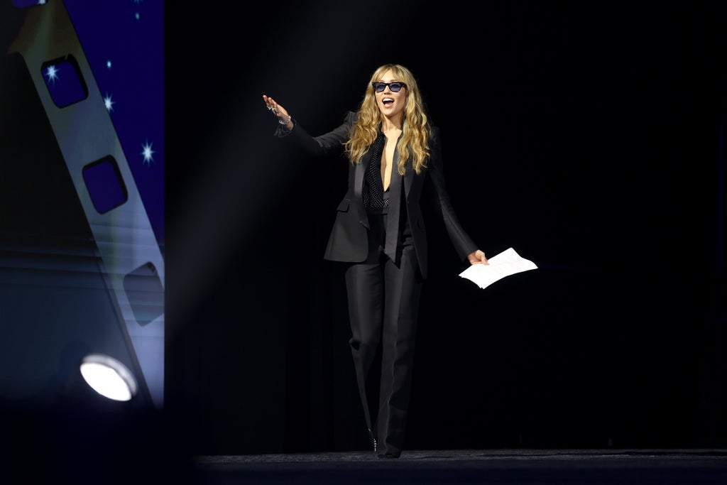 Miley Cyrus walks on-stage with a speech in her hand at the Palm Springs International Film Awards