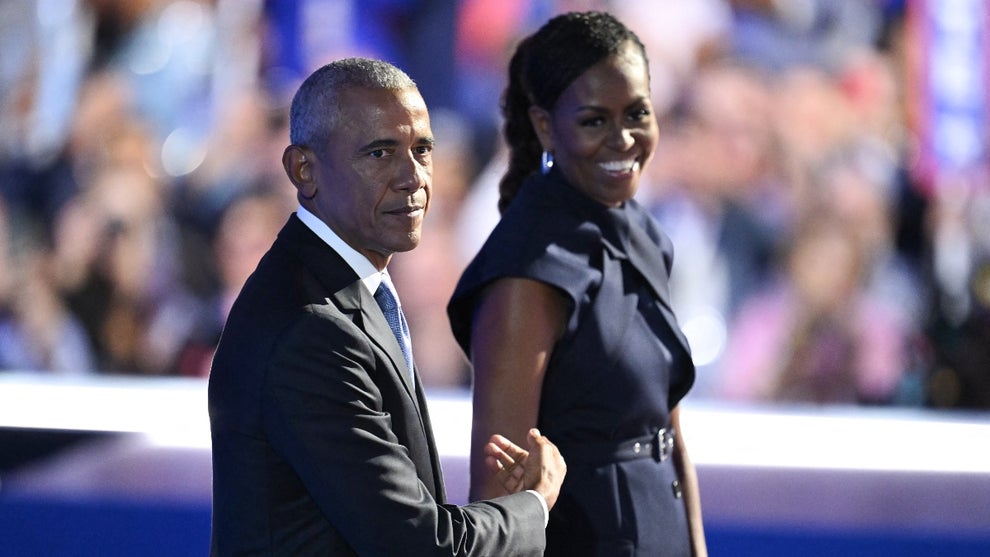 Former US President Barack Obama and his wife and former First Lady Michelle Obama stand on stage after she introduced him on the second day of the Democratic National Convention (DNC) at the United Center in Chicago, Illinois, on August 20, 2024