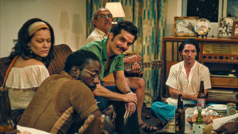 A still from "The Secret Agent" of Armando (Wagner Moura) and other political refugees at Dona Sebastiana's (Tânia Maria) shelter.