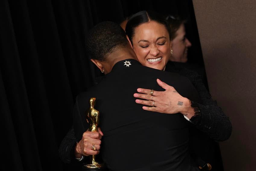 Michael B. Jordan, wearing a David Yurman brooch, hugs cinematographer Autumn Durald Arkapaw, Oscar winner for Best Cinematography for Sinners. Source: Getty