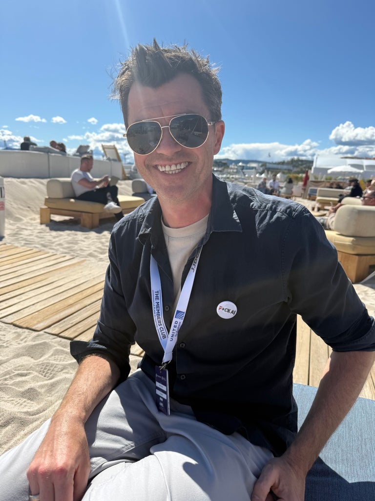 Todd Mann wears a "Fuck AI" pin at the Cannes Film Festival