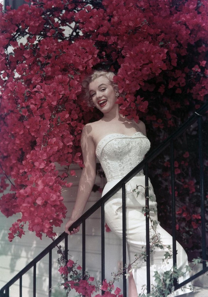 Marilyn Monroe poses for a portrait on a stair case among blooming pink flowers circa 1950. Source: Michael Ochs Archives/Getty Images