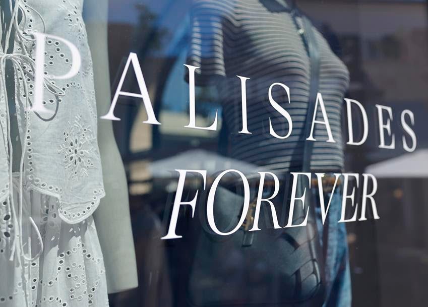 A sign reads "Palisades Forever" at a shop on reopening day of Palisades Village, Aug. 15, 2026. Source: Getty
