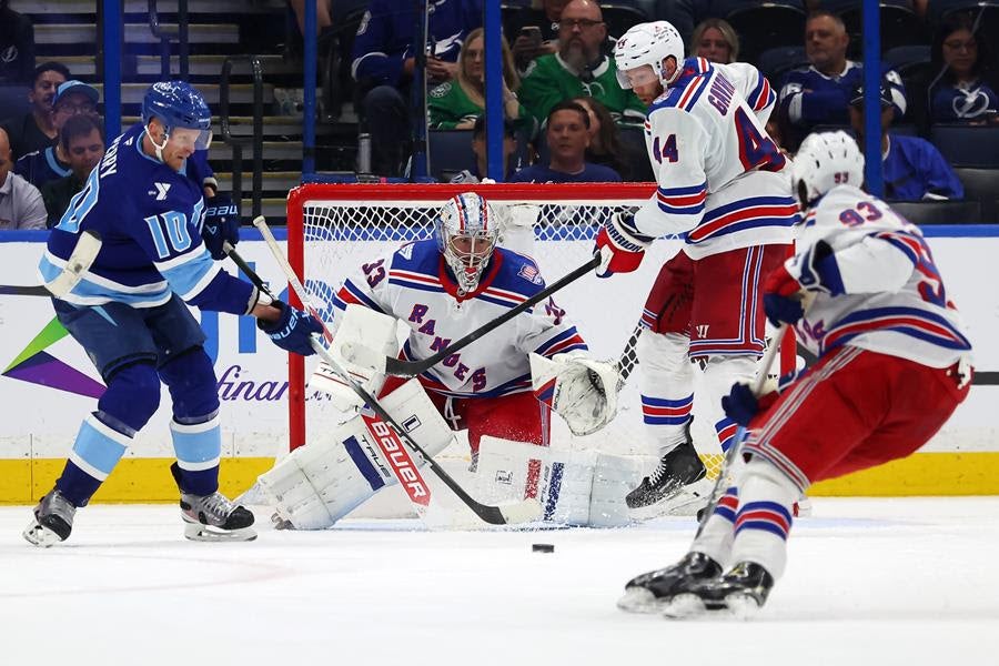 Corey Perry #10 of the Tampa Bay Lightning reaches to tip a puck in front of Dylan Garand of the New York Rangers as Vladislav Gavrikov defends. (Credit: Mike Carlson/Getty Images)