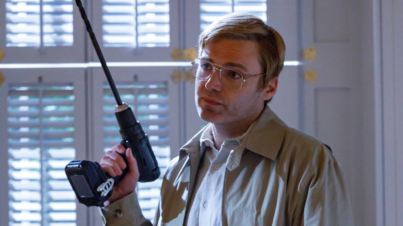 Seth Gabel as serial killer Jeffrey Dahmer in AHS 13, standing in front of blinds while holding a drill